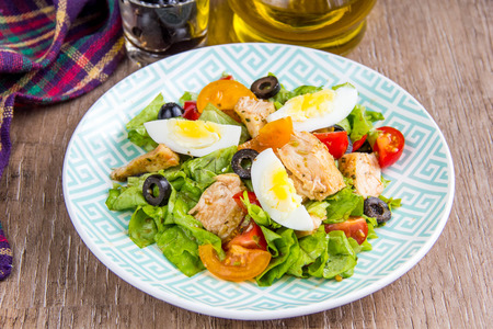 Green salad with chicken, lettuce, egg, olives, tomatoesの写真素材