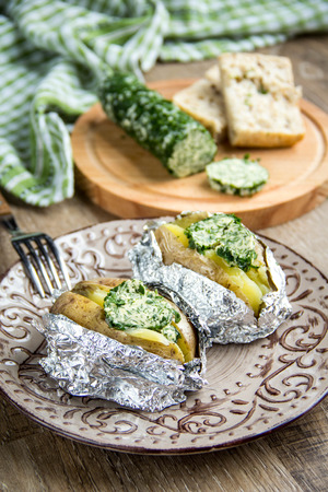 Baked potatoes with herbs butter, with green homemade butter, tasty foodの写真素材