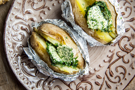 Baked potatoes with herbs butter, with green homemade butter, tasty foodの写真素材