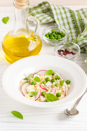 Salad with couscous, green peas, mozzarella and radish, summer healthy dishの写真素材