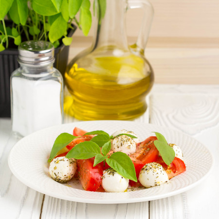 Italian fresh tomato Caprese salad, mozzarella and Basil, delicious light summer snackの写真素材