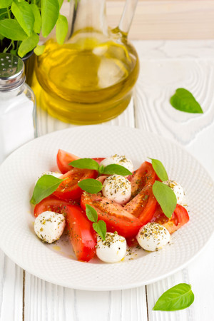 Italian fresh tomato Caprese salad, mozzarella and Basil, delicious light summer snackの写真素材