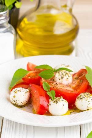 Italian fresh tomato Caprese salad, mozzarella and Basil, delicious light summer snackの写真素材