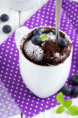 Chocolate cake in a mug with blueberry and powdered sugar, delicious summer dessertの写真素材