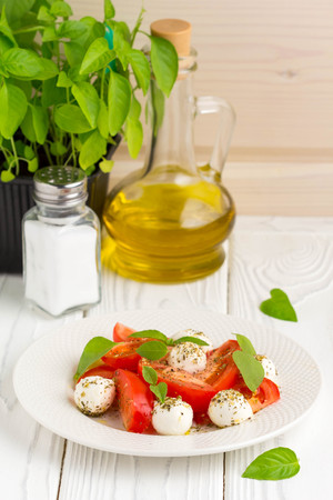 Italian fresh tomato Caprese salad, mozzarella and Basil, delicious light summer snackの写真素材