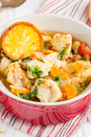 Fish stew with vegetables and rice, delicious healthy dinner, lemon, spices, breadの写真素材