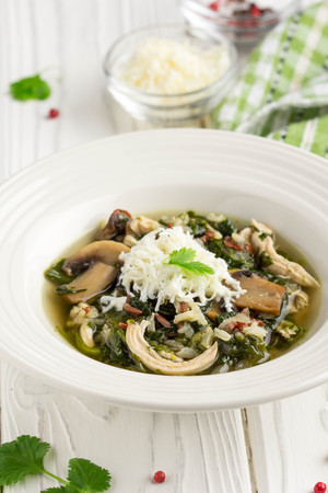 Healthy soup with spinach, chicken, rice, mushrooms and feta cheese, delicious lunch, diet foodの写真素材