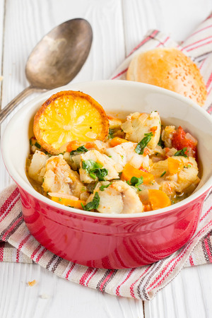 Fish stew with vegetables and rice, delicious healthy dinner, lemon, spices, breadの写真素材