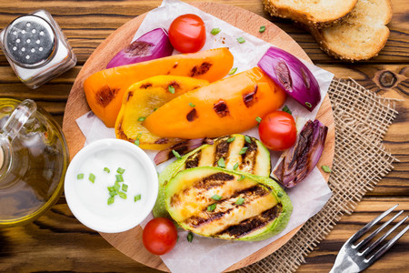 Grilled vegetables with sauce, zucchini, bell peppers, red onions, tomatoes, summer picnicの写真素材