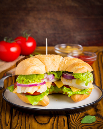 Croissant sandwich with chicken, vegetables, cheese, tomato, onion, delicious healthy lunchの写真素材