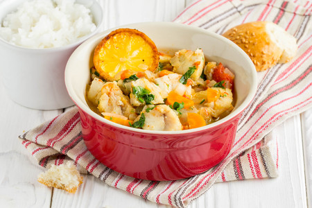 Fish stew with vegetables and rice, delicious healthy dinner, lemon, spices, breadの写真素材