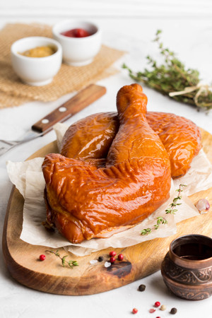 Smoked chicken legs on a board with ketchup, mustard and thyme, tatsy dishの写真素材