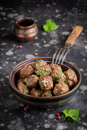Beef meatballs in a bowl with sauce, brown with sesame and parsley, delicious snackの写真素材