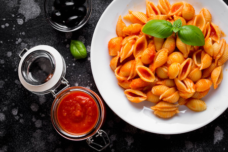 Italian shell pasta with tomato sauce, olives and Basil, classic foodの写真素材
