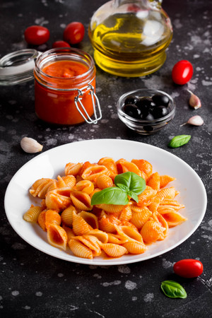 Italian shell pasta with tomato sauce, olives and Basil, classic foodの写真素材