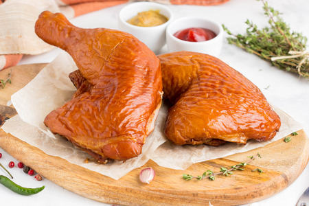 Smoked chicken legs on a board with ketchup, mustard and thyme, tatsy dishの写真素材
