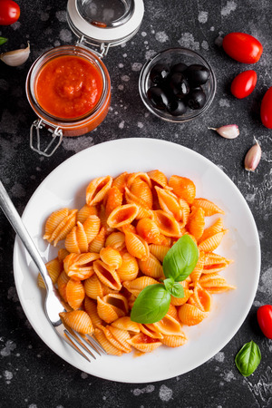 Italian shell pasta with tomato sauce, olives and Basil, classic foodの写真素材