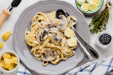 Italian pasta tagliatelle with mushroom cream sauce, cheese and thyme delicious homemade dinnerの写真素材