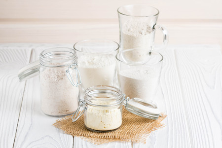 Different flour in glass jars, wheat, corn, rye, oats, spelt, flaxの写真素材