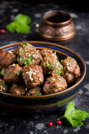 Beef meatballs in a bowl with sauce, brown with sesame and parsley, delicious snackの写真素材