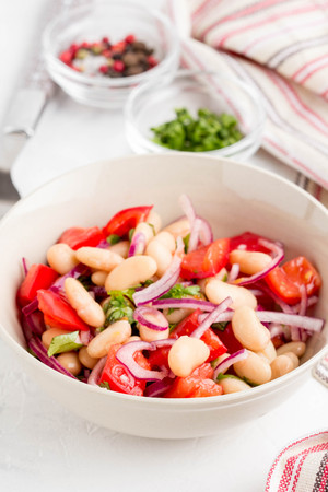 Salad with white beans, tomatoes, red onions, green coriander, parsley, delicious diet lunchの写真素材