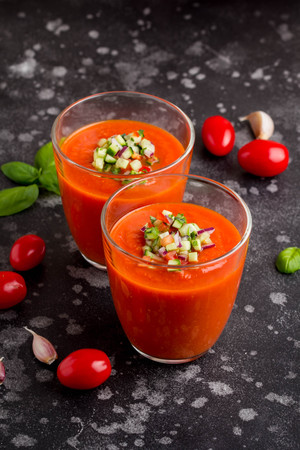 Italian red tomato cold gazpacho soup in glass, with cucumber, onion, Basilの写真素材