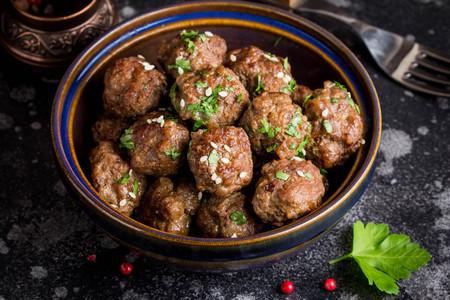 Beef meatballs in a bowl with sauce, brown with sesame and parsley, delicious snackの写真素材