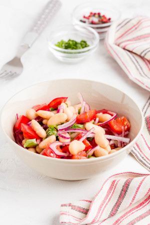 Salad with white beans, tomatoes, red onions, green coriander, parsley, delicious diet lunchの写真素材
