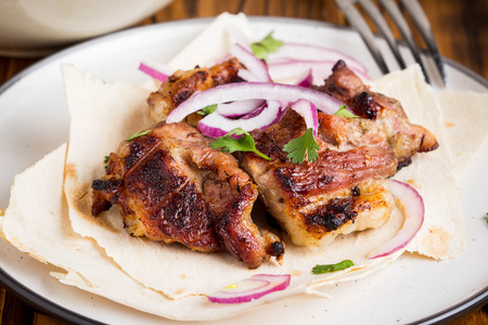 Kebab, pieces of meat, beef, pork on thin pita with onion and saladの写真素材