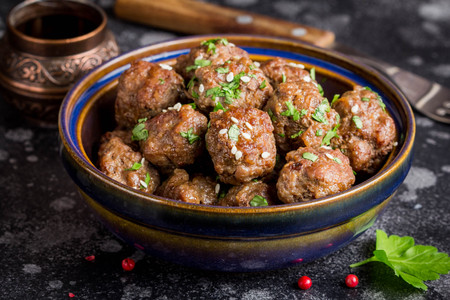 Beef meatballs in a bowl with sauce, brown with sesame and parsley, delicious snackの写真素材