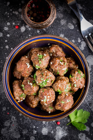 Beef meatballs in a bowl with sauce, brown with sesame and parsley, delicious snackの写真素材