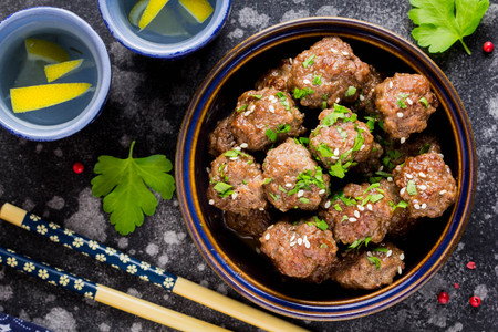 Beef meatballs in a bowl with sauce, brown with sesame and parsley, delicious snackの写真素材