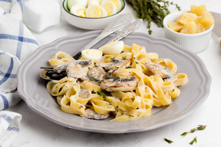 Italian pasta tagliatelle with mushroom cream sauce, cheese and thyme delicious homemade dinnerの写真素材