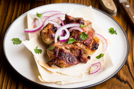 Kebab, pieces of meat, beef, pork on thin pita with onion and saladの写真素材