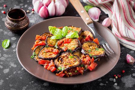 Fried eggplant slices with tomatoes, herbs and garlic, tasty vegetarian summer snack. Grilled aubergineの写真素材