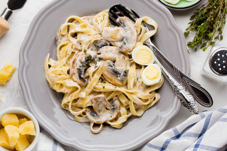 Italian pasta tagliatelle with mushroom cream sauce, cheese and thyme delicious homemade dinnerの写真素材