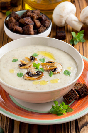Mushroom cream soup with cream, croutons of dark bread, olive oil, delicious healthy foodの写真素材