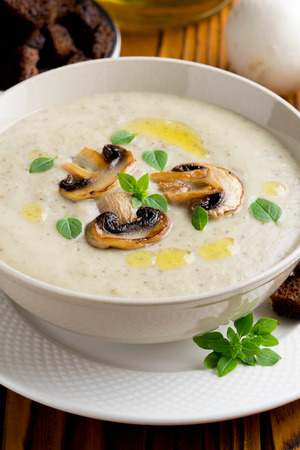 Mushroom cream soup with cream, croutons of dark bread, olive oil, delicious healthy foodの写真素材