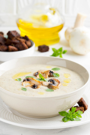Mushroom cream soup with cream, croutons of dark bread, olive oil, delicious healthy foodの写真素材