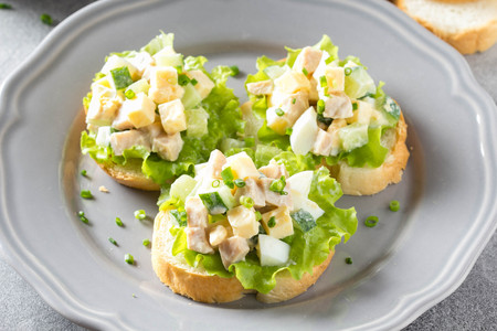 Sandwiches with squid meat salad, cucumber, egg, cheese and mayonnaise. Canapes in tartlets, Russian snack. Delicious food for Breakfast and holidayの写真素材