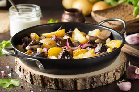 Fried potatoes with forest mushrooms, boletus, onions and sour cream.の写真素材