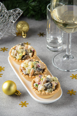 Russian salad with meat in a tartlet. With potatoes, egg, cucumber, onion, mushrooms and mayonnaise.の写真素材