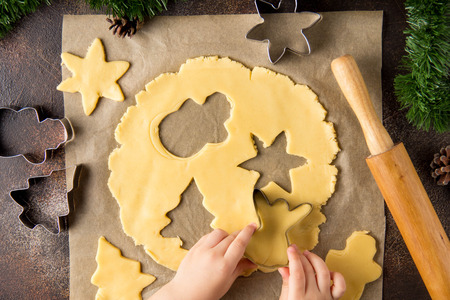 Children is cooking Christmas cookies, cut the dough with cookie cutter, family traditions, delicious sweet holiday foodの写真素材
