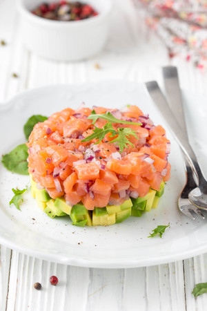 Salmon tartar with red onion, avocado, arugula and bread toast.の写真素材