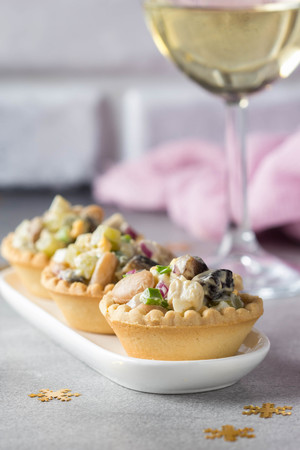 Russian salad with meat in a tartlet. With potatoes, egg, cucumber, onion, mushrooms and mayonnaise.の写真素材