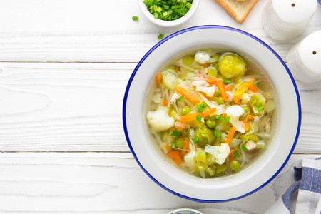 Vegetable soup with cauliflower, Brussels sprouts, white cabbage, carrots and green peasの写真素材