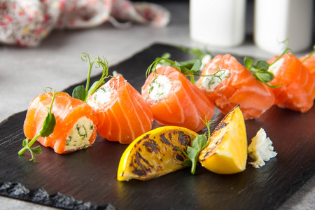 Salmon rolls stuffed with cream cheese and herbs, beautiful snack, elegant food for menu. Tasty dishの写真素材