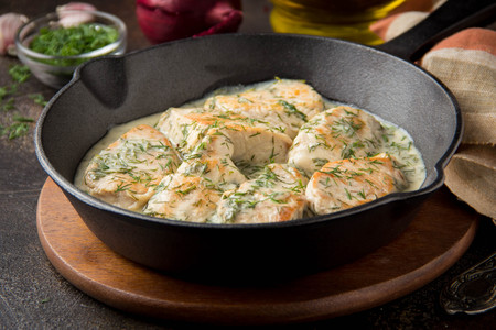 Chicken fillet or Turkey breast in creamy sauce with dill and garlic, in cast iron black panの写真素材