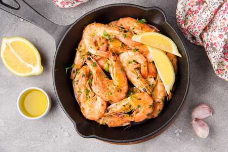 Fried shrimps in shell with parsley, coriander, garlic and oil in pan. Tasty mediterranean cuisine, vegetarian food, healthy proteinの写真素材