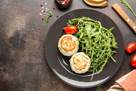 Fried chicken cutlet with herbs, delicious healthy lunch, children's food, diet. Meatballs with salad on dark backgroundの写真素材